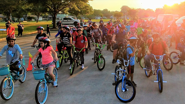 A large group of kids riding bicycles