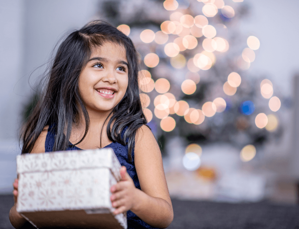 A young girl holding a holiday gift